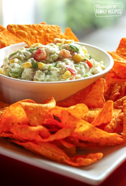 Dorito Dip in a white bowl surrounded by Nacho Cheese Doritos