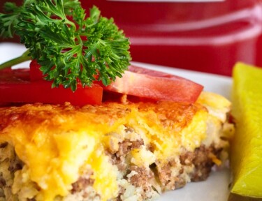 Easy Cheeseburger Pie topped with tomatoes and a garnish