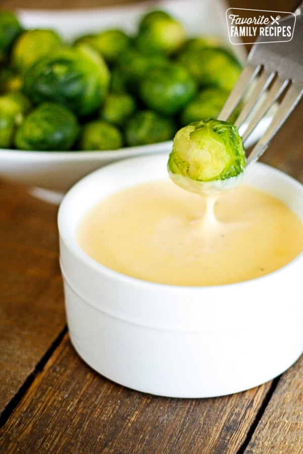 Brussel Sprout being dipped into Cheese Sauce