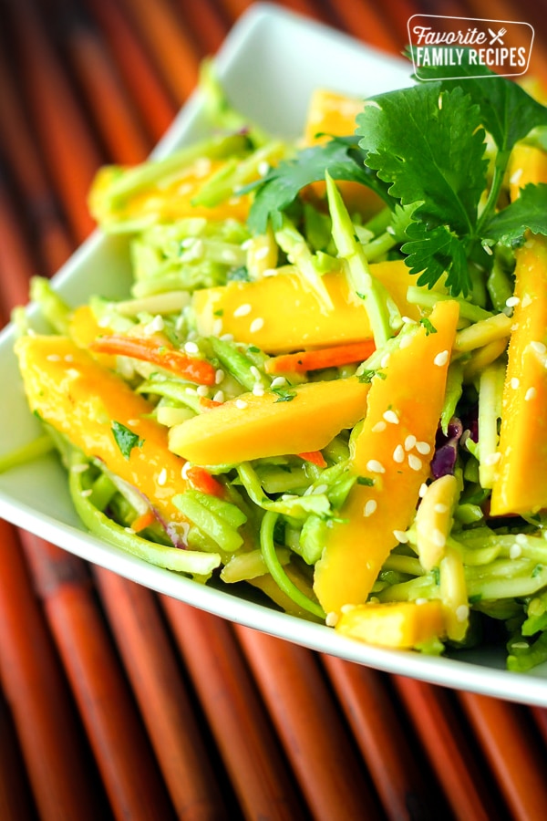 Fresh Mango Avocado Coleslaw topped with a garnish in a white bowl.