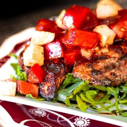 Close up of Grilled Balsamic Chicken with a chilled Bruschetta Topping on a plate.