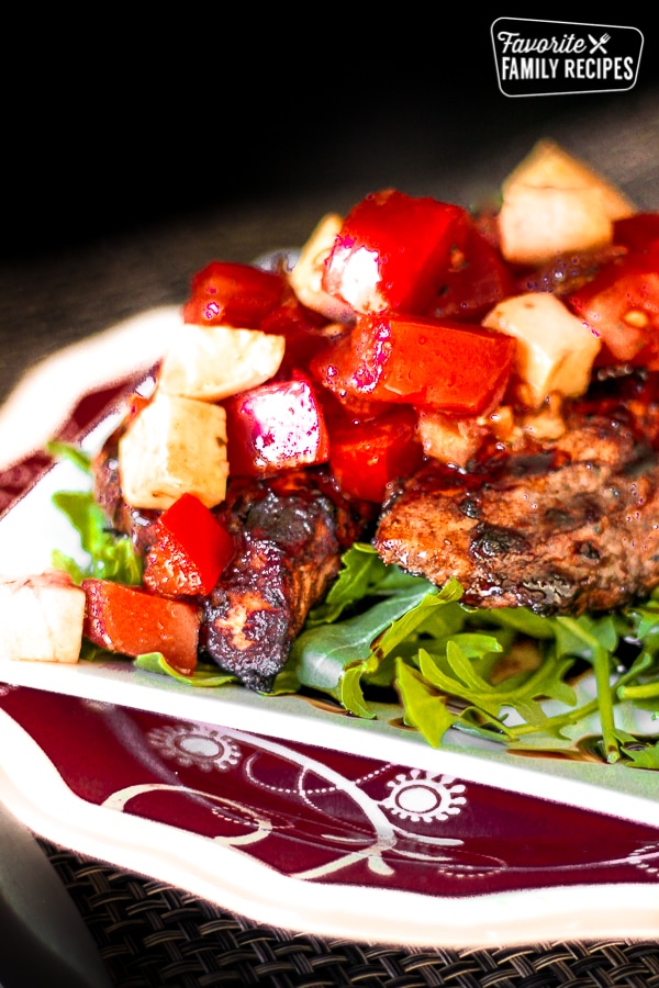 Close up of Grilled Balsamic Chicken with a chilled Bruschetta Topping on a plate.