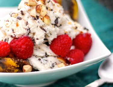 Grilled Banana Split Boats topped with ice cream and raspberries.