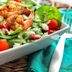 Grilled Shrimp Salad with Cilantro Verde Dressing in a white bowl with a fork on the side.