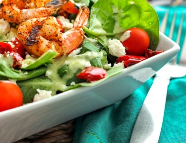 Grilled Shrimp Salad with Cilantro Verde Dressing in a white bowl with a fork on the side.