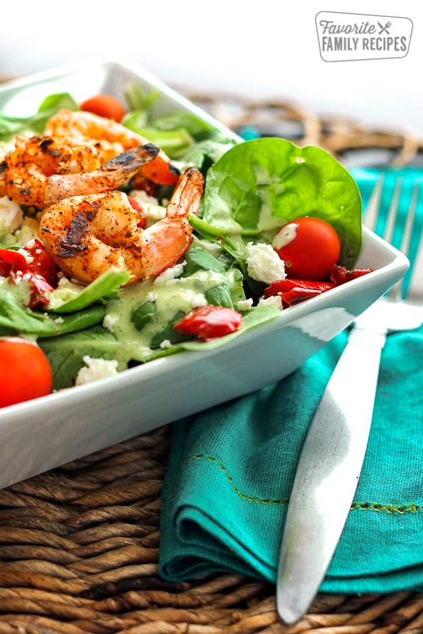 Grilled Shrimp Salad with Cilantro Verde Dressing in a white bowl with a fork on the side.