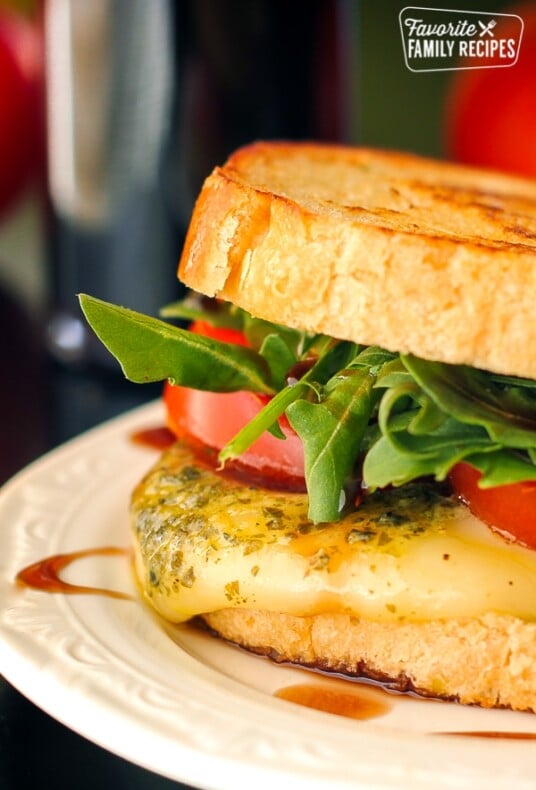 Margherita grilled cheese sandwich on a white plate.