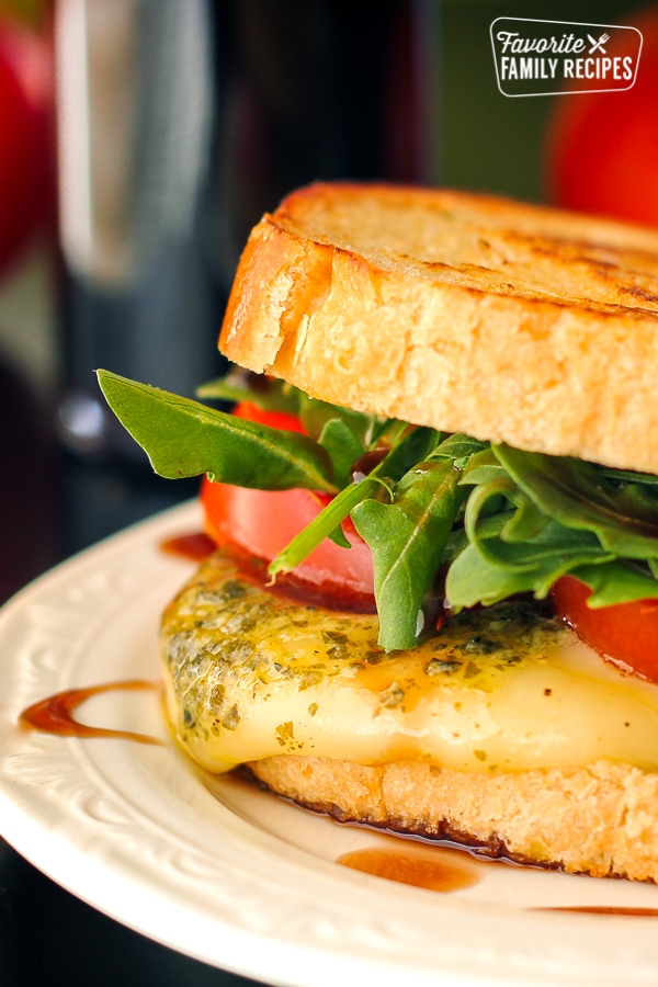 Margherita grilled cheese sandwich on a white plate. 