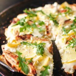 Lemon Chicken Pizza with a slice poking out on a pizza pan