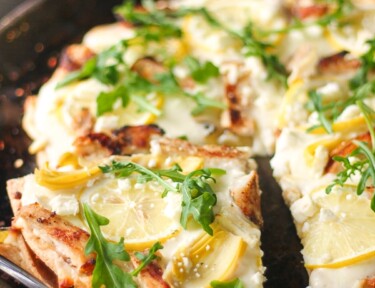 Lemon Chicken Pizza with a slice poking out on a pizza pan