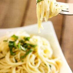 Fresh and Easy Lemon Spaghetti in a bowl with a fork in focus with noodles swirled around it.