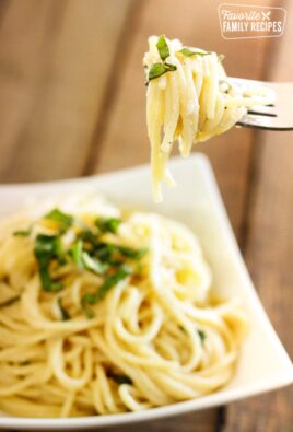 Fresh and Easy Lemon Spaghetti in a bowl with a fork in focus with noodles swirled around it.