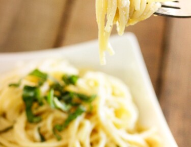 Fresh and Easy Lemon Spaghetti in a bowl with a fork in focus with noodles swirled around it.