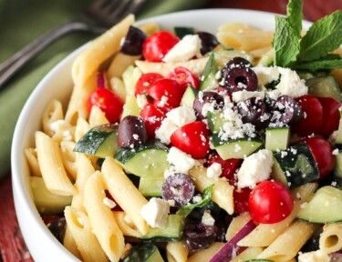 Light Greek Pasta Salad in a white Bowl with a fork on the side.