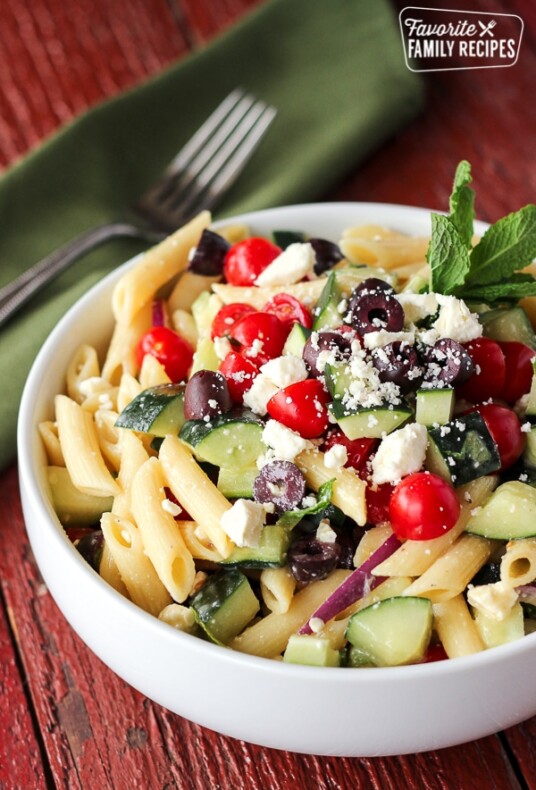Light Greek Pasta Salad in a white Bowl with a fork on the side.