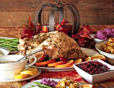 A low calorie Thanksgiving Dinner with turkey, gravy, cranberry sauce and stuffing on a decorated tablecloth