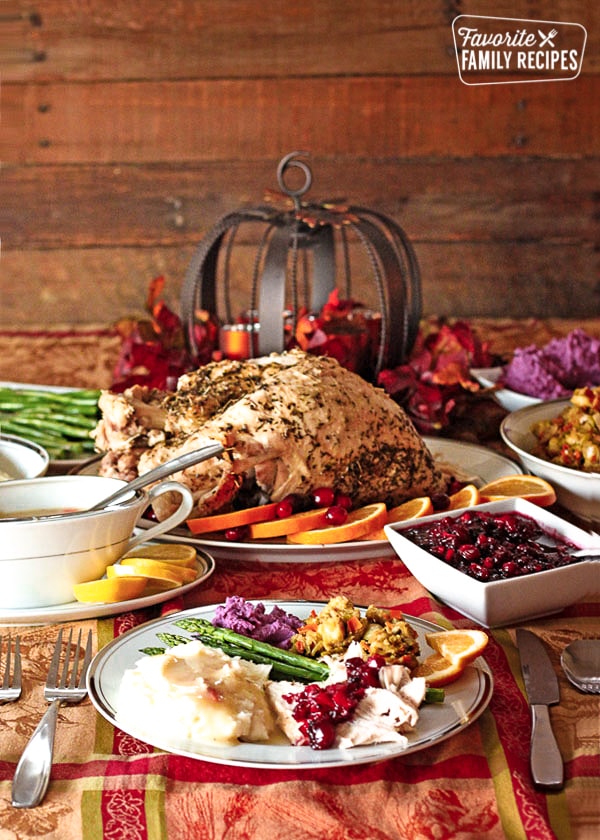 A low calorie Thanksgiving Dinner with turkey, gravy, cranberry sauce and stuffing on a decorated tablecloth.