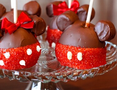 4 Mickey and Minnie Caramel Apples on a glass tray.