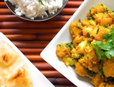 Curried Cauliflower and Potatoes in a Dish with Naan Bread on the side