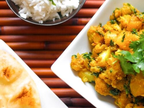 Curried Cauliflower and Potatoes in a Dish with Naan Bread on the side
