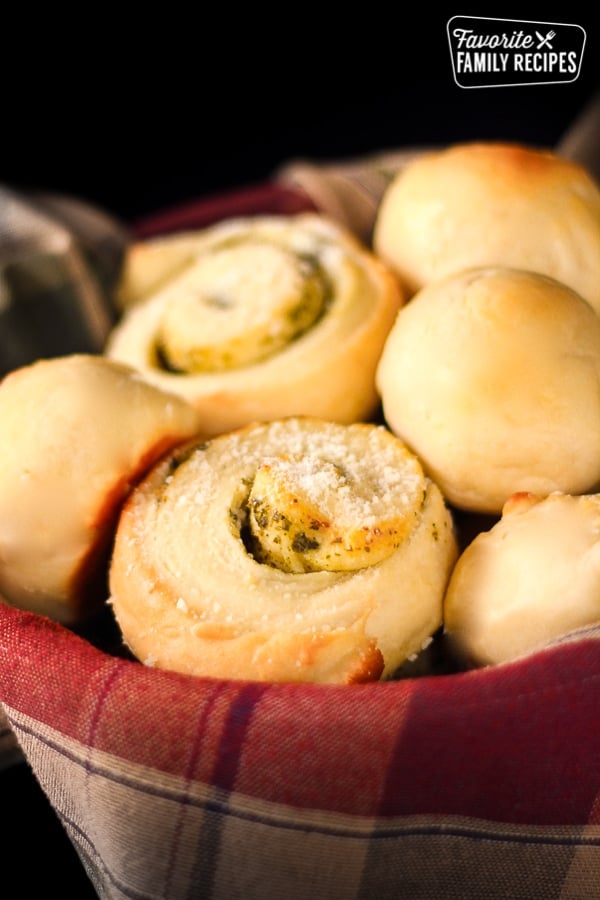 Moms Rolls and Pesto Rolls in a bread basket with a plaid napkin