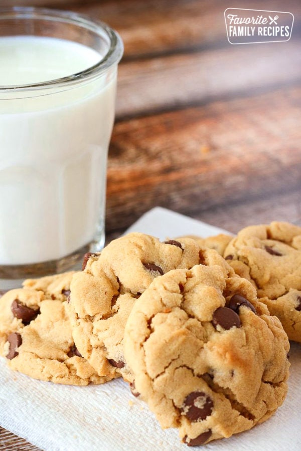 A plate of peanut butter chocolate chip cookies with a glass of milk to the side