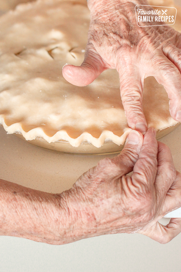 Pie crusts being pressed together with fingers