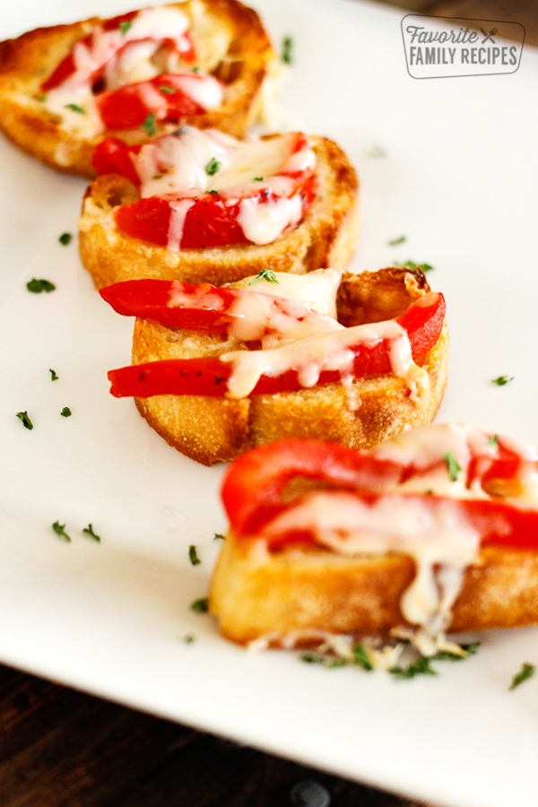 Red pepper bruschetta on a white platter. 