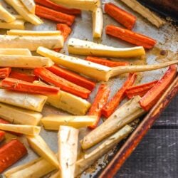 Roasted parsnip and carrot sticks on a baking sheet