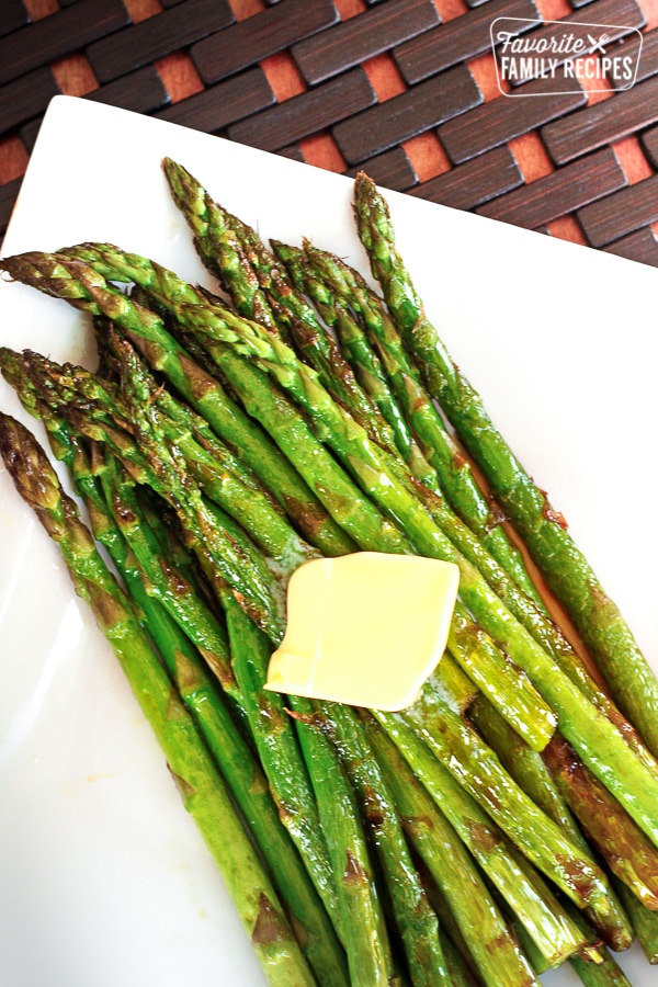 Sautéed Sweet Asparagus on a plate with a square of butter melting on top