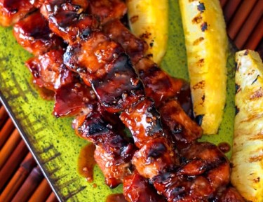 Pork Kabobs on a serving platter with pineapple