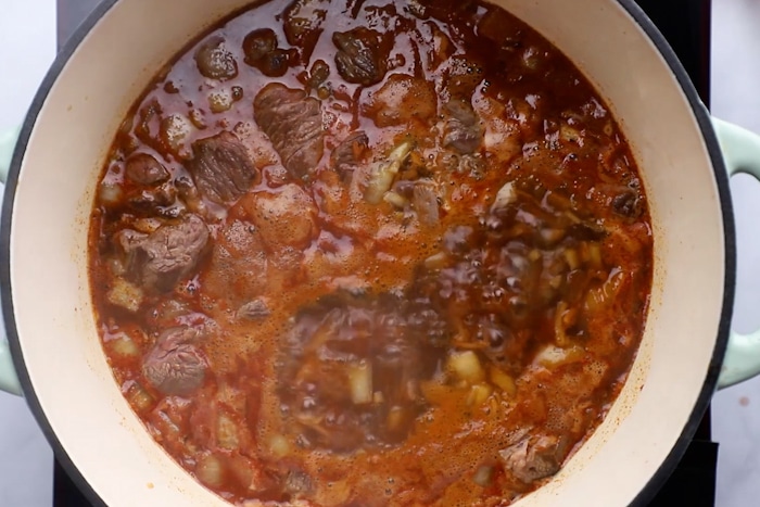 Simmering ingredients in a large pot for Thick and Beefy Danish Goulash.