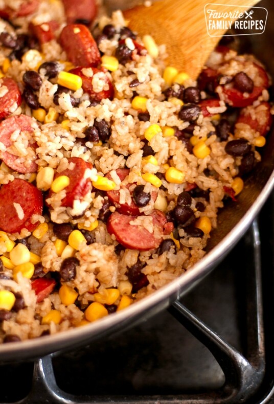 A skillet filled with sausage and rice with black beans and corn