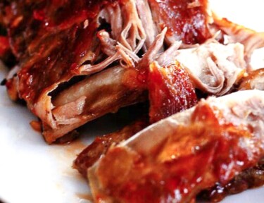 A plate of Sweet and Spicy Crock Pot Ribs with meat coming off the bone
