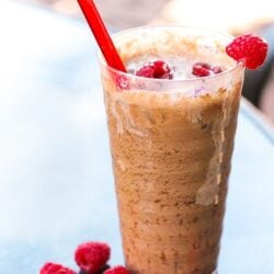 Swigs Raspberry Dream topped with fresh raspberries in a glass cup.