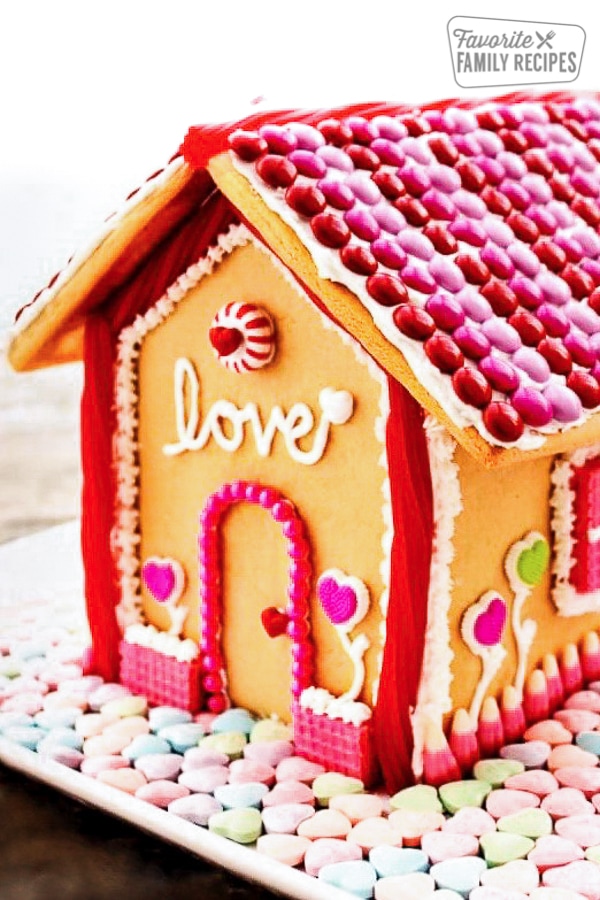 Valentine gingerbread house covered in candy. 