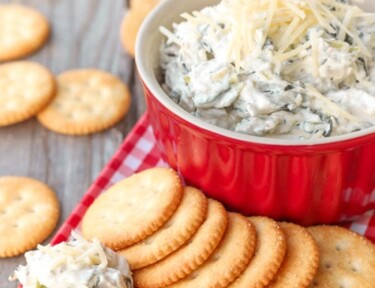 plate of crackers with easy spinach dip in red bowl