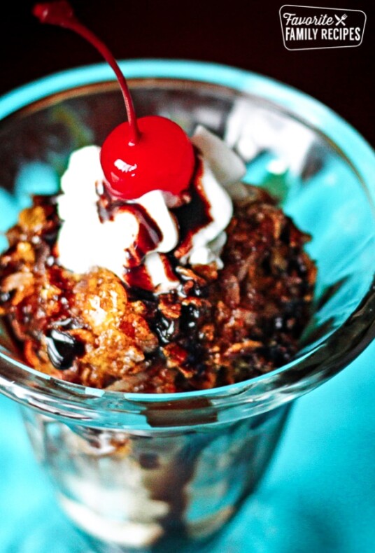Fried Ice Cream topped with whipped cream and a cherry in a glass bowl.