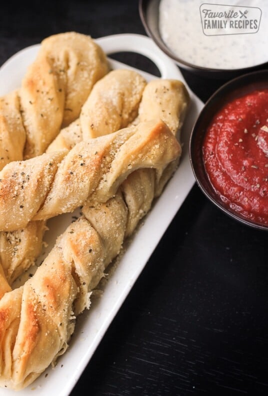 4 Pizza Factory Breadtwists on a white tray with a side of marina sauce and ranch.