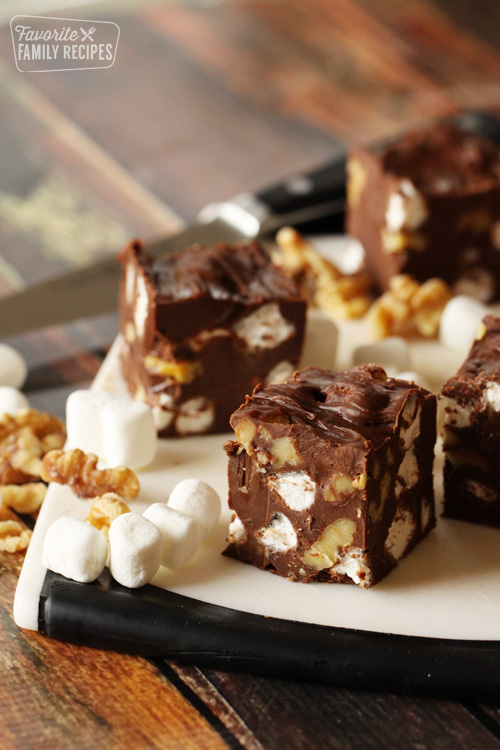 Pieces of rocky road fudge with marshmallows and walnuts on a cutting board