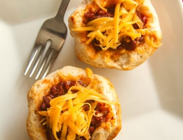 Sloppy joe cups with a fork on the side with a white plate.