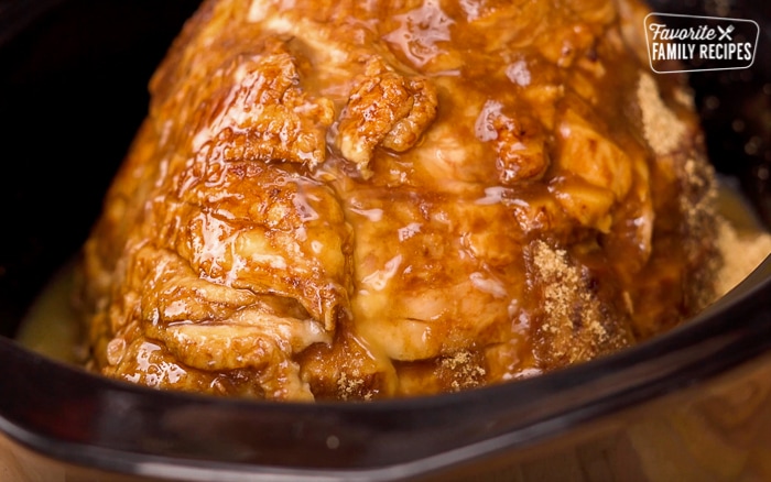 Adding ingredients to cooked ham in a slow cooker