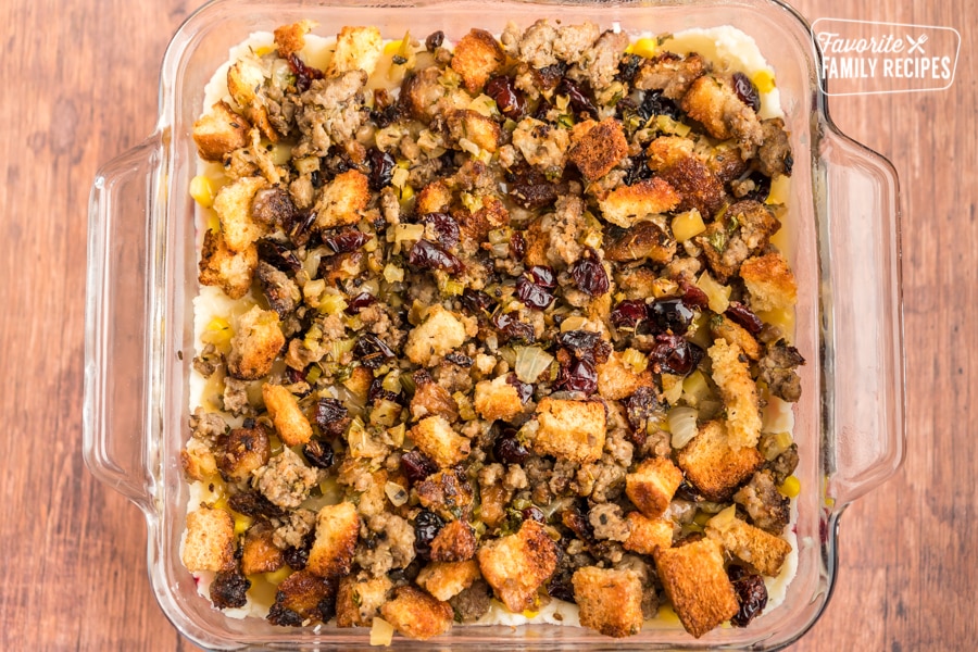 Stuffing on top of a thanksgiving leftover casserole in a glass baking dish