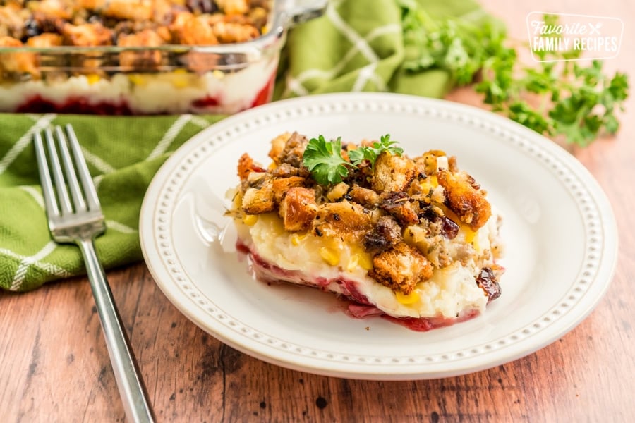 A scoop of Thanksgiving Leftover Casserole on a white plate with a fork next to it