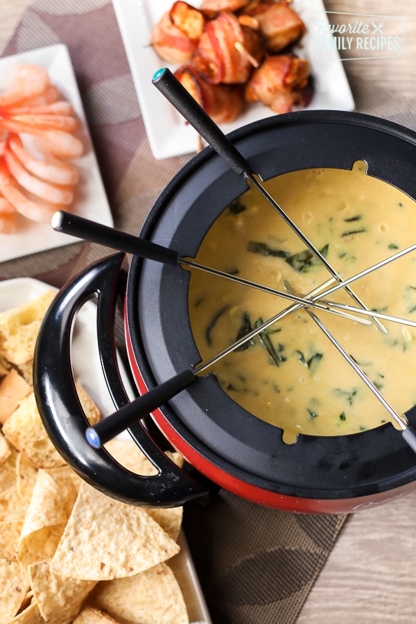 The Melting Pot's Spinach Artichoke Cheese Fondue is one of my favorite copycat recipes. Smooth, creamy melted cheese with spinach and artichokes that add incredible flavor! Melting Pot’s Spinach Artichoke Cheese Fondue with skewers.