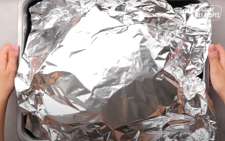 Placing foil over turkey for cooking