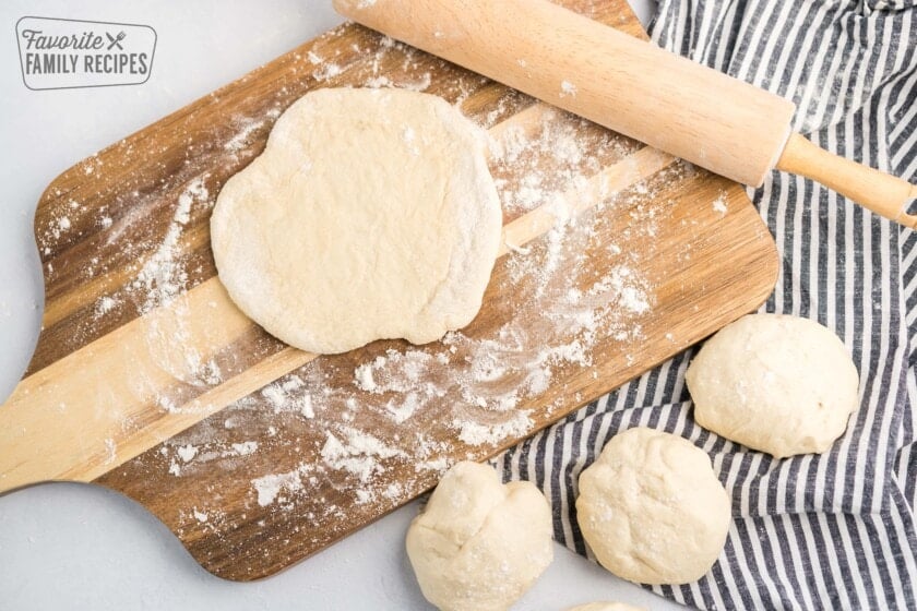 Balls of bread dough being rolled out into circles