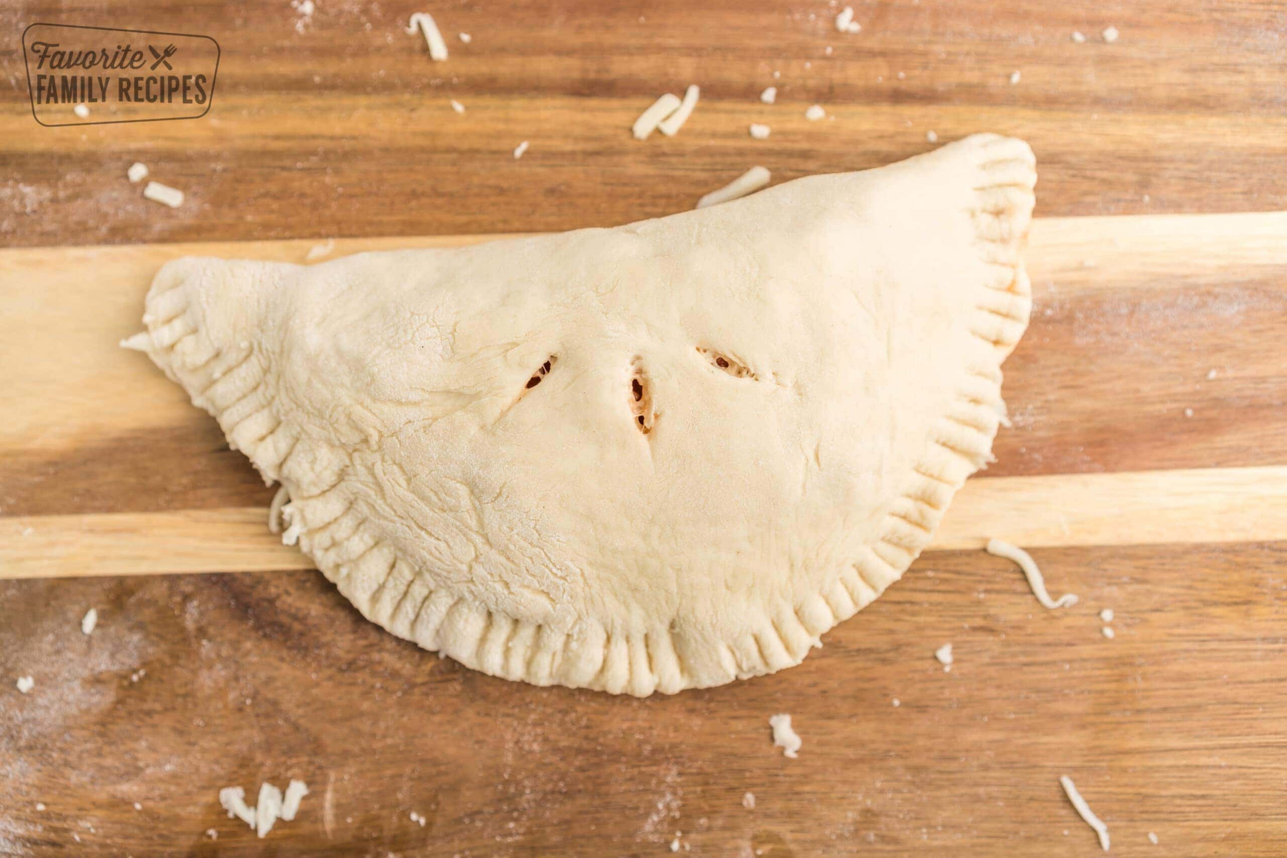 An uncooked calzone on a cutting board