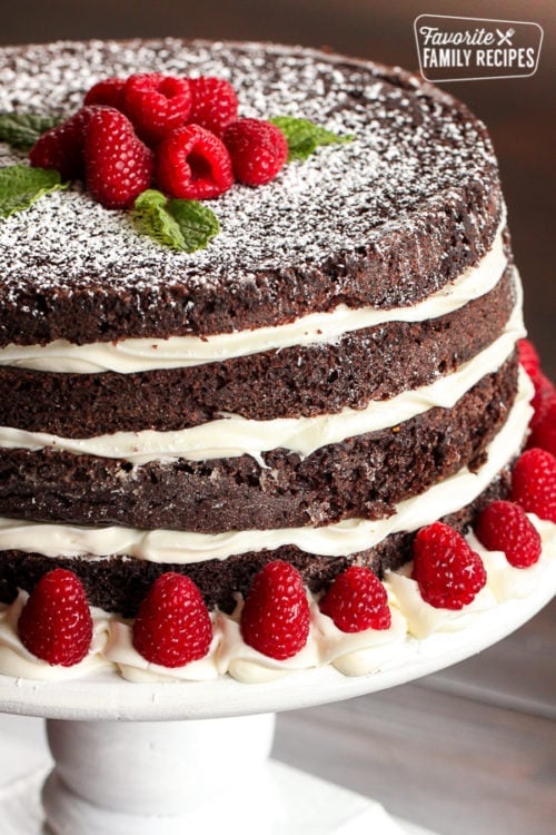 Chocolate cake on a white cake stand.