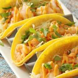 Three shrimp tacos on a plate